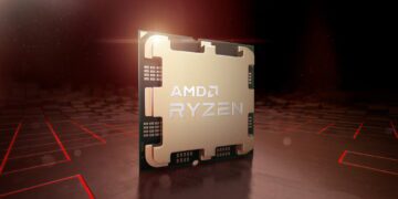 نمای نزدیک از تراشه AMD Ryzen با لوگوی برجسته AMD و Ryzen روی پوشش فلزی طلاییرنگ، در محیطی با نور قرمز.