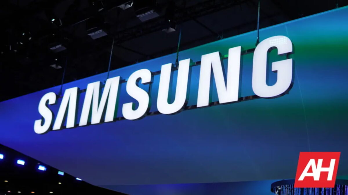 تابلوی بزرگ و نورپردازیشده SAMSUNG در یک نمایشگاه یا رویداد فناوری، با پسزمینه آبی و سبز و واترمارک AH در گوشه پایین تصویر.