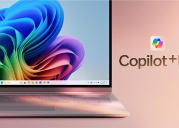 نمای نزدیک از لپ‌تاپی با والپیپر رنگارنگ ویندوز ۱۱ و لوگوی درخشان Copilot+ PC در کنار صفحه‌نمایش.