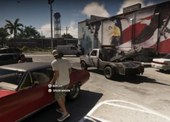 صحنه‌ای از گیم‌پلی بازی GTA 6 با حضور شخصیت جیسون در حال سرقت ماشین کلاسیک قرمز و نمایش راهنمای دکمه‌های کنترل بازی در پارکینگ روبروی فروشگاه.
