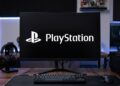 یک مانیتور گیمینگ خمیده در مرکز روی میز کار چوبی که لوگوی سفیدرنگ و بزرگ «PlayStation» روی صفحه کاملا مشکی آن نقش بسته است. یک کیبورد مکانیکی کوچک بدون کلیدهای ماشین‌حساب (TKL)، یک موس گیمینگ لاجیتک در سمت راست و یک هدفون گیمینگ مشکی روی پایه مخصوص در سمت چپ مانیتور قرار گرفته‌اند.