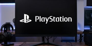 یک مانیتور گیمینگ خمیده در مرکز روی میز کار چوبی که لوگوی سفیدرنگ و بزرگ «PlayStation» روی صفحه کاملا مشکی آن نقش بسته است. یک کیبورد مکانیکی کوچک بدون کلیدهای ماشینحساب (TKL)، یک موس گیمینگ لاجیتک در سمت راست و یک هدفون گیمینگ مشکی روی پایه مخصوص در سمت چپ مانیتور قرار گرفتهاند.