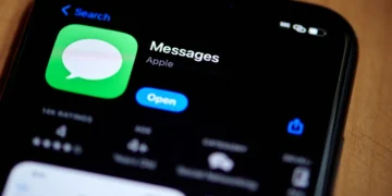 نمای نزدیک از صفحه جست‌وجوی اپلیکیشن Messages در آیفون که آیکون Messages، عنوان برنامه، توضیح Apple Networking و دکمه آبی Open را نشان می‌دهد.