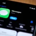 نمای نزدیک از صفحه جستوجوی اپلیکیشن Messages در آیفون که آیکون Messages، عنوان برنامه، توضیح Apple Networking و دکمه آبی Open را نشان میدهد.