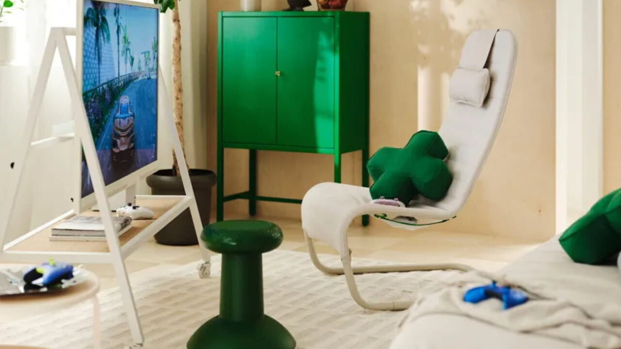صندلی راحتی سفید مجموعه IKEA و Xbox با پشتی بلند، کوسن گردنی سفید و کوسن سبز، در کنار کابینت سبز و میز کوچکی با دسته بازی.