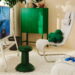 صندلی راحتی سفید مجموعه IKEA و Xbox با پشتی بلند، کوسن گردنی سفید و کوسن سبز، در کنار کابینت سبز و میز کوچکی با دسته بازی.