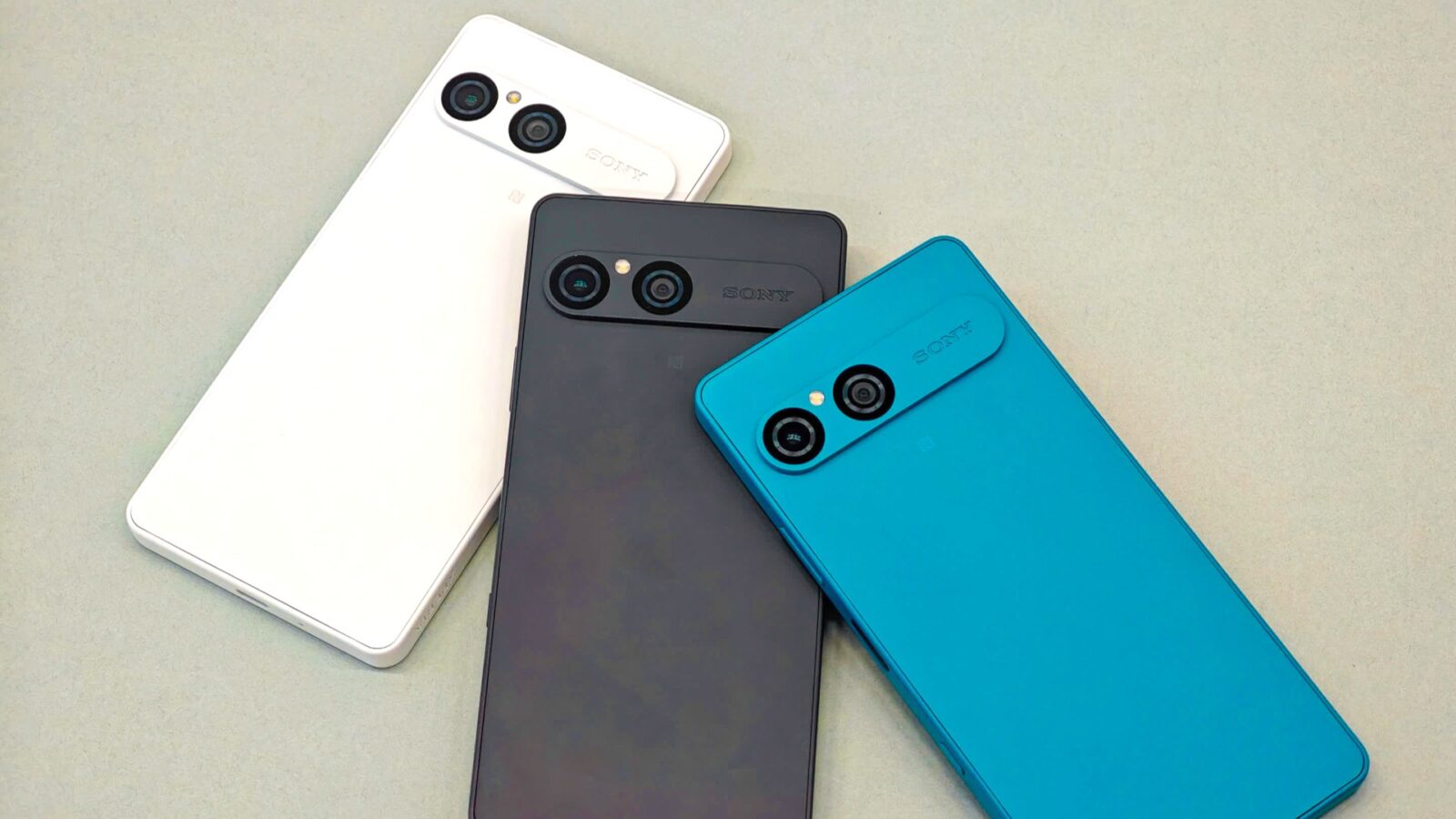 سه گوشی Sony Xperia در رنگهای سفید، مشکی و آبی فیروزهای، با نمای پشتی و ماژول دوربین دوگانه افقی، روی سطحی روشن.