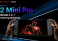 کنسول بازی دستی مشکی‌رنگ OneXPlayer X2 Mini Pro در دست با نمایش تصویر والپیپر روبات جنگنده و حلقه‌های نوری دور جوی‌استیک‌ها.