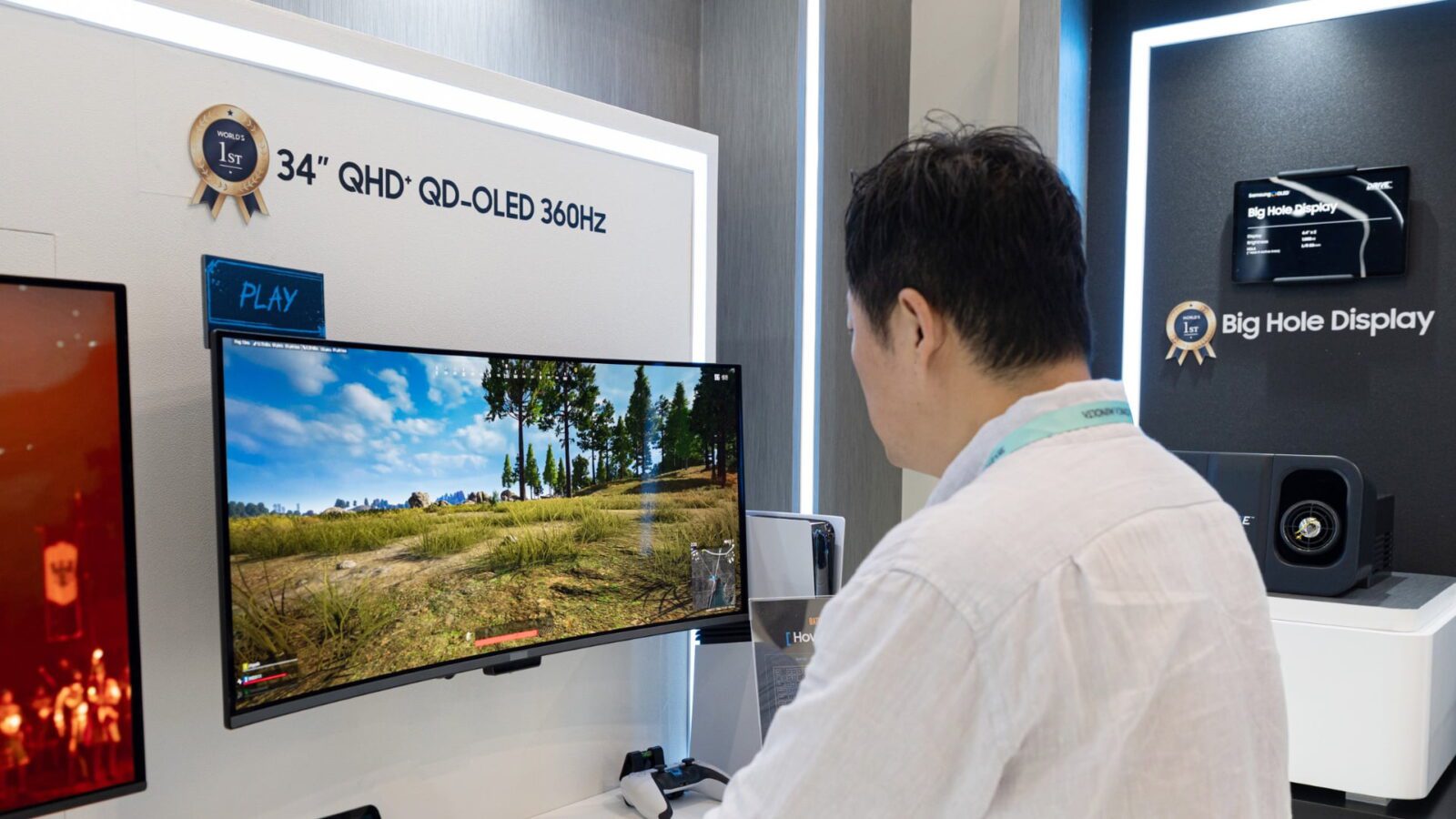 بازدیدکننده‌ای در حال تماشای مانیتور فوق عریض ۳۴ اینچی QHD پلاس QD-OLED با نرخ نوسازی ۳۶۰ هرتز و نمایش یک بازی ویدیویی در نمایشگاه.