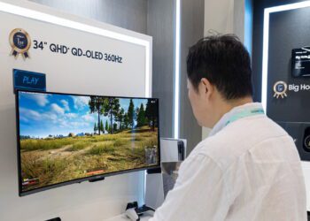 بازدیدکننده‌ای در حال تماشای مانیتور فوق عریض ۳۴ اینچی QHD پلاس QD-OLED با نرخ نوسازی ۳۶۰ هرتز و نمایش یک بازی ویدیویی در نمایشگاه.