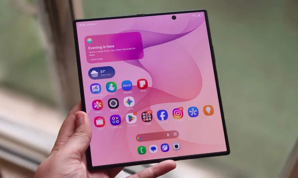 فردی گوشی تاشوی سامسونگ Galaxy Z Fold 8 Ultra را در حالت کاملا باز با صفحه اصلی صورتی رنگ در دست گرفته است.