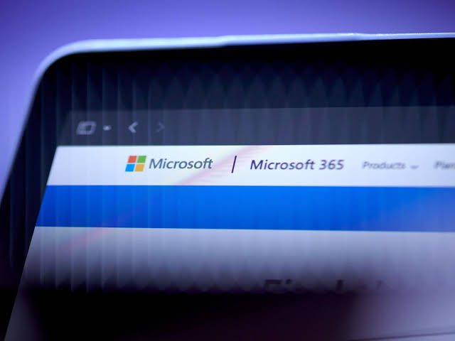 نمای نزدیک از صفحهنمایش رایانه با نوار بالایی وبسایت Microsoft 365 و منوی محصولات مایکروسافت.
