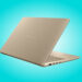 نمای مایل از پشت درپوش بژ مات لپتاپ ایسوس زنبوک با لوگوی متنی ASUS Zenbook در پسزمینهای به رنگ آبی فیروزهای.