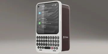 تلفن همراه Clicks Communicator با بدنه سفید و درپوش شارژ زرشکی در نمای زاویهدار روی پسزمینه خاکستری که صفحه نمایش آن اعلانهای پیامرسانهایی مانند Telegram، Slack، WhatsApp و Gmail را نمایش میدهد و کیبورد فیزیکی QWERTY در پایین دیده میشود.