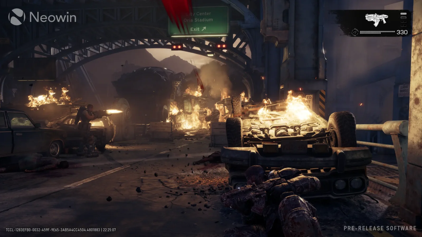 اسکرینشات گیمپلی از صحنه نبرد و تیراندازی بازی Gears of War: E-Day در خیابانی ویرانشده با ماشینهای آتشگرفته، تابلو خروجی بزرگراه و لوگوی Neowin