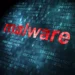 طرح مفهومی امنیت سایبری و بدافزار با کلمه قرمز رنگ و درخشان malware روی پس‌زمینه‌ای از کدهای دیجیتال هگزادسیمال، بیت‌های داده و ماتریس باینری آبی تیره.