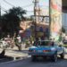 صحنهای از بازی GTA 6 با ماشین کلاسیک آبی، موتورسواران در حال تکچرخ زدن و ستونهای نقاشیشده پل در وایس سیتی.