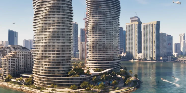 نمای سینمایی برج‌های مسکونی دو قلوی موج‌دار شیشه‌ای Vice City در پس‌زمینه آسمان آبی صاف، با برج‌های مسکونی شهر در پس‌زمینه، درختان نخل روی برآمدگی‌های جزیره و قایق‌های متحرک در آب‌های فیروزه‌ای روشن؛ پل‌های طولانی در افق دوردست دیده می‌شوند و یک بالگرد در پرواز است.