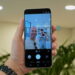 نمای دستی که گوشی Samsung Galaxy S26 FE را در حالت Photo گرفته؛ صفحه نمایش پیشنمایش دوربین، دو نفر در محیط صنعتی روشن و چند دکمهی تنظیمات از قبیل Portrait و Video را نشان میدهد.