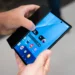 نمای دست‌های دو نفر از بالا روی گوشی تاشو سه‌بعدی سامسونگ Galaxy Z TriFold روشن