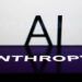 نمای افقی صفحهنمایش یک گوشی هوشمند با لوگوی سفید تایپوگرافی شرکت ANTHROPIC روی پسزمینه بنفش در پیشزمینه، با حروف بزرگ AI در پسزمینه تار و سفید.