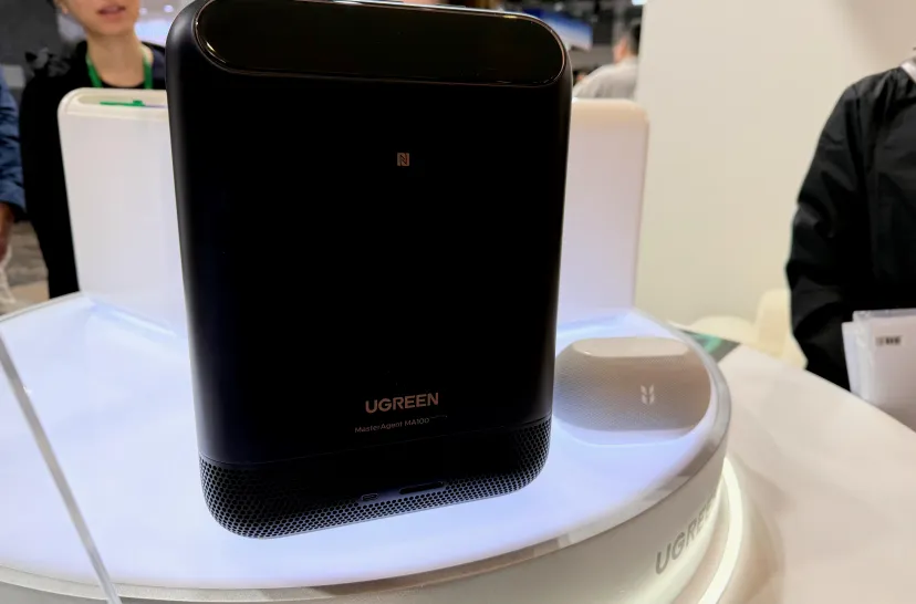 پنل جلویی ذخیرهساز هوشمند مشکی رنگ برند UGREEN مجهز به علامت NFC و بلندگوی هوشمند کوچک در کنار آن روی استند نمایشگاه.