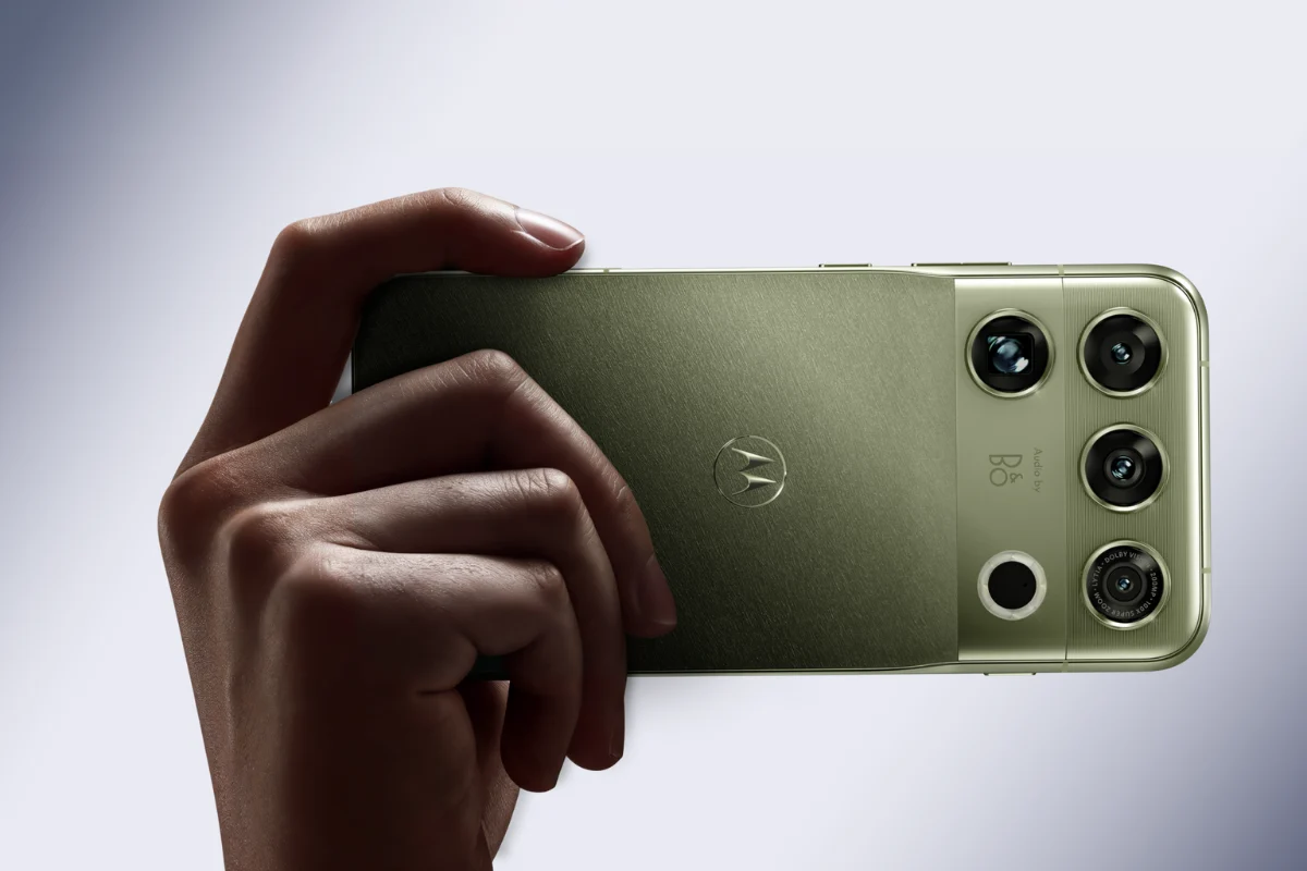 نمای پشت گوشی سبز زیتونی Motorola Signature که در دست نگه داشته شده و ماژول دوربین چندگانه آن با لنزهای گرد در گوشه بدنه دیده میشود.