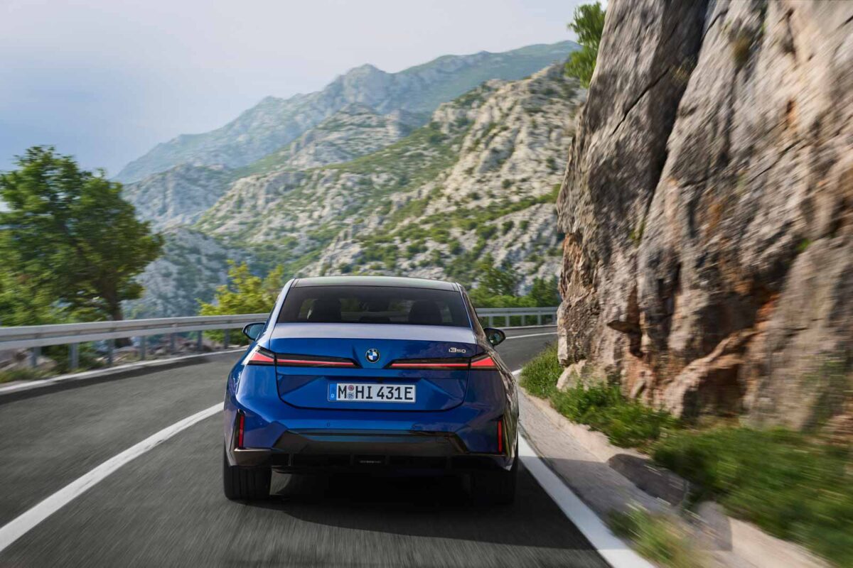 نمای عقب BMW i3 50 xDrive آبی در مسیر کوهستانی