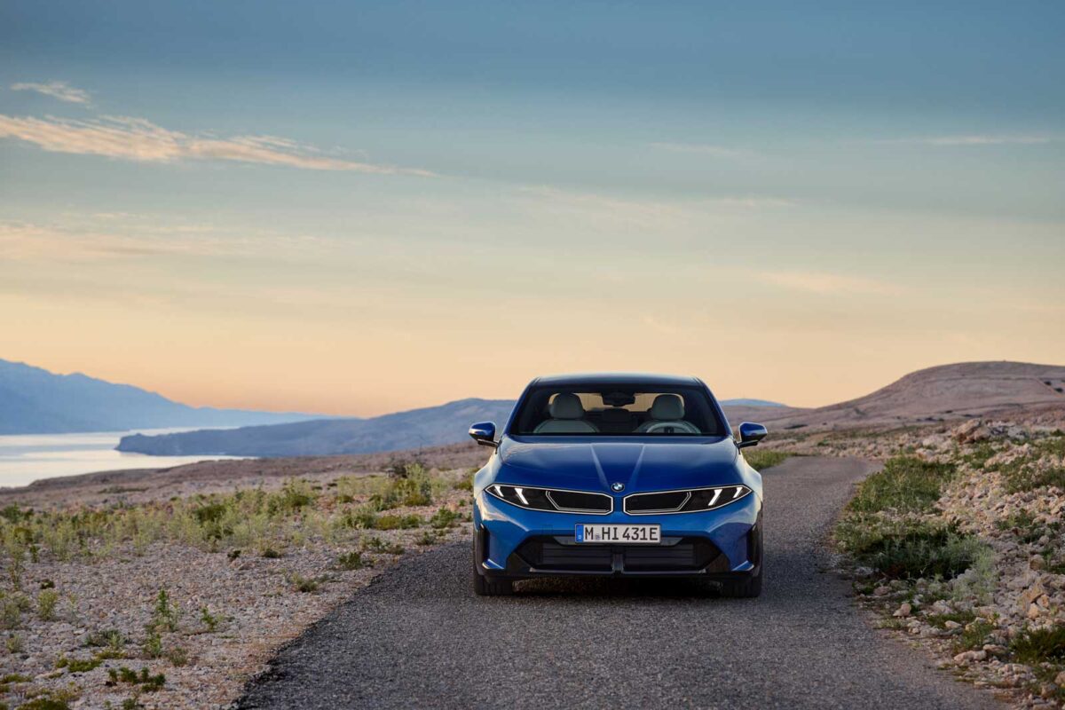 نمای روبهرو BMW i3 50 xDrive آبی در جادهای کوهستانی