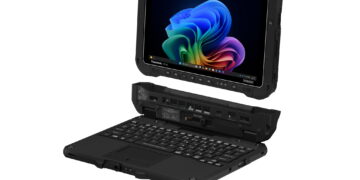 نمای سهبعدی و نیمهزاویهدار از تبلت مقاوم صنعتی Panasonic FZ-G3 که بالای داک کیبورد مشکی با پورتها و پینهای اتصال معلق شده و نمایشگر روشن آن با رابط کاربری ویندوز ۱۱ روی پسزمینه مشکی دیده میشود.