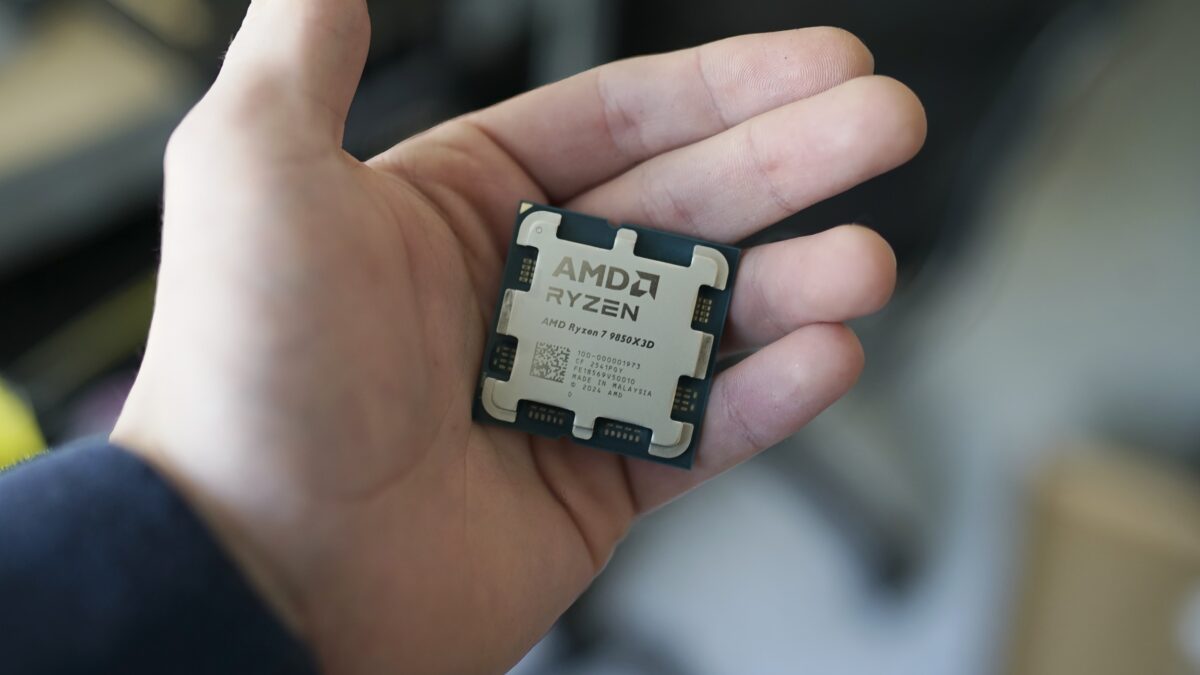 پردازنده کامپیوتری AMD Ryzen 7 9850X3D با درپوش فلزی در کف دست یک فرد.