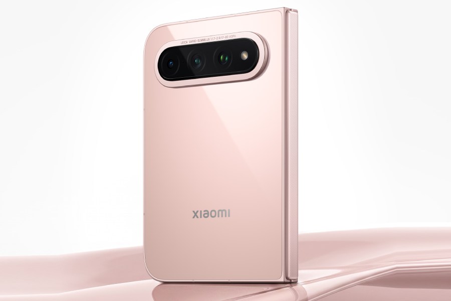 پشت گوشی تاشو Xiaomi 18 Fold نسخه سرامیکی با بدنه صورتی روشن براق و ماژول دوربین افقی سهگانه با حلقه طلایی که روی سطح صدفی صورتی در نور استودیویی ایستاده است.