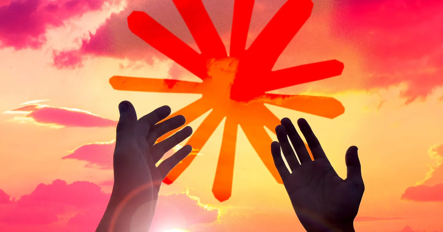 نمای نزدیک از دو دست انسان که به سمت خورشید و لوگوی ستارهایشکل قرمز و نارنجی در آسمان غروب دراز شدهاند