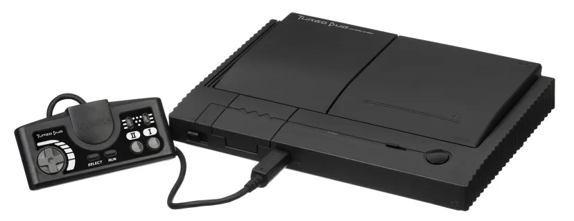 کنسول کلاسیک بازی TurboDuo به رنگ مشکی مات همراه با کنترلر سیمی اختصاصی و شیار دیسک در پسزمینه سفید.
