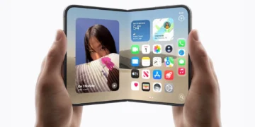 دستهایی که یک iPhone Duo مفهومی را در حالت کاملاً باز نگه داشتهاند؛ نمایشگر گسترده دستگاه رابط کاربری iOS، ویجت آبوهوا، عکس و آیکونهای برنامهها را نشان میدهد.