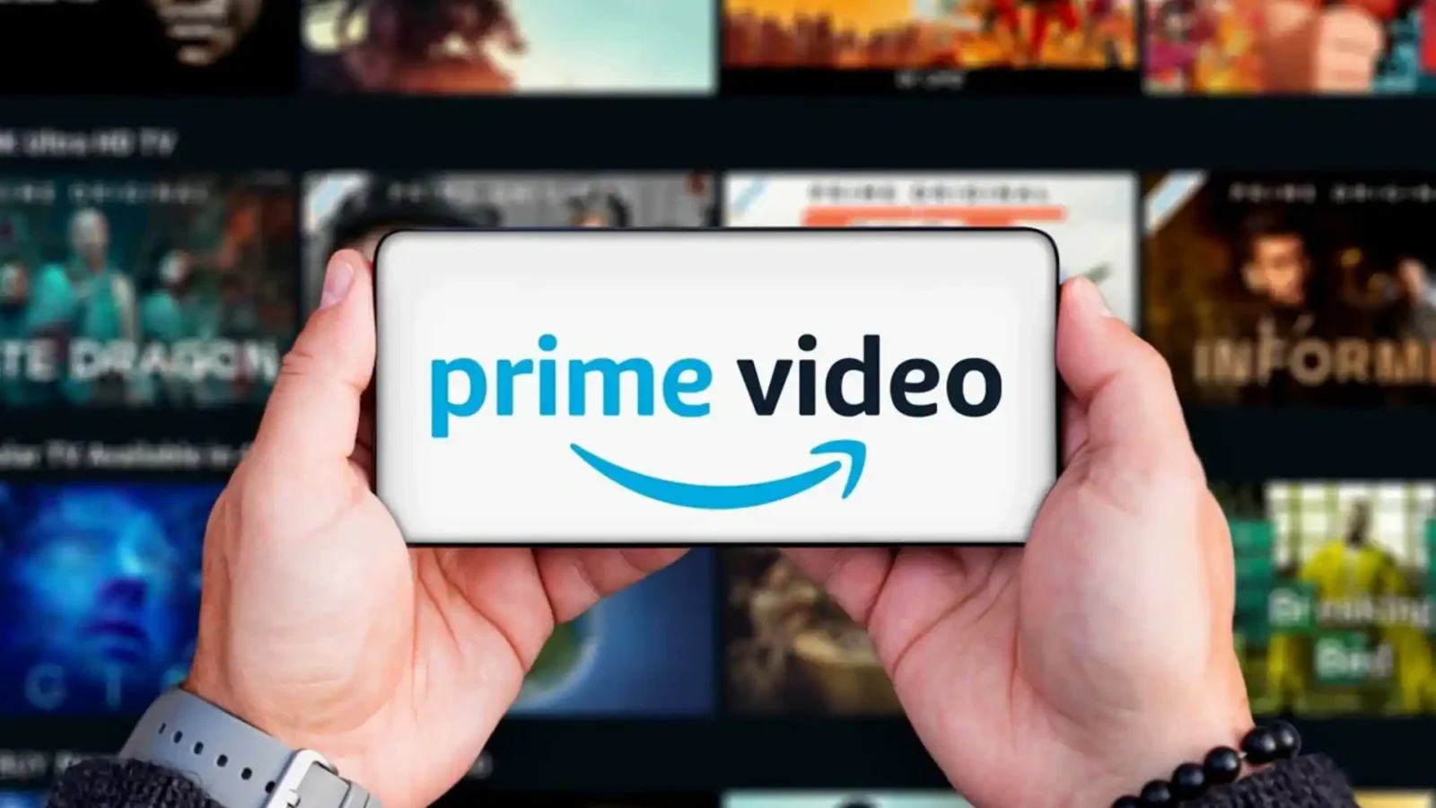 دو دست یک گوشی موبایل را به صورت افقی گرفتهاند که لوگوی آبی و مشکی Prime Video با آیکون لبخند آمازون روی نمایشگر آن درج شده است؛ پسزمینه تار، شبکهای از کاورهای محتوای ویدئویی سرویس استریم را نشان میدهد.