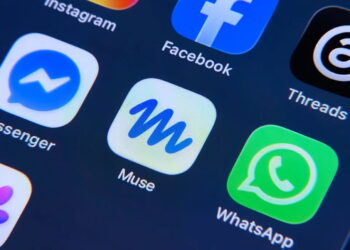 آیکون سفید رنگ اپلیکیشن Muse با نماد M موج‌دار آبی در میان آیکون‌های WhatsApp، Messenger، Facebook و Threads روی صفحه گوشی هوشمند.
