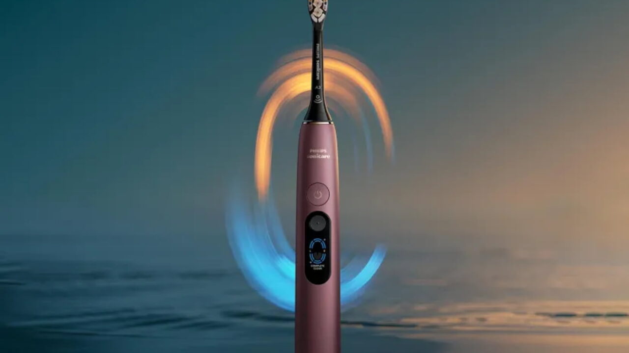 مسواک برقی هوشمند Philips Sonicare به رنگ برنزی متالیک همراه با خطوط نورانی آبی و طلایی چرخان در اطراف سری مسواک