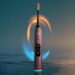مسواک برقی هوشمند Philips Sonicare به رنگ برنزی متالیک همراه با خطوط نورانی آبی و طلایی چرخان در اطراف سری مسواک