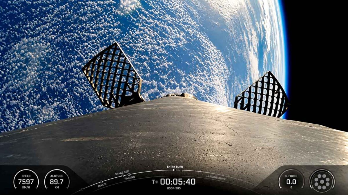نمای بوستر فالکون ۹ و بالکهای مشبک آن در فضا هنگام مأموریت USSF-385 با زمین در پسزمینه
