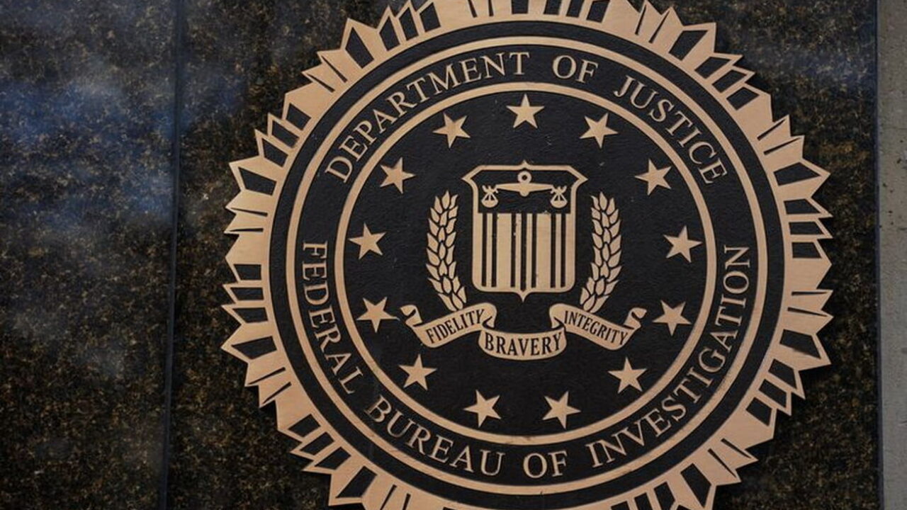نشان رسمی وزارت دادگستری آمریکا و اداره تحقیقات فدرال FBI روی دیوار سنگی تیره، با عبارت‌های Department of Justice و Federal Bureau of Investigation.