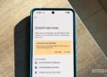 گوشی پیکسل روی میز چوبی در حال نمایش منوی خدمات سیستم گوگل (System services) و گزینه‌های به‌روزرسانی برنامه‌ها.