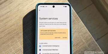 گوشی پیکسل روی میز چوبی در حال نمایش منوی خدمات سیستم گوگل (System services) و گزینه‌های به‌روزرسانی برنامه‌ها.