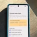 گوشی پیکسل روی میز چوبی در حال نمایش منوی خدمات سیستم گوگل (System services) و گزینه‌های به‌روزرسانی برنامه‌ها.