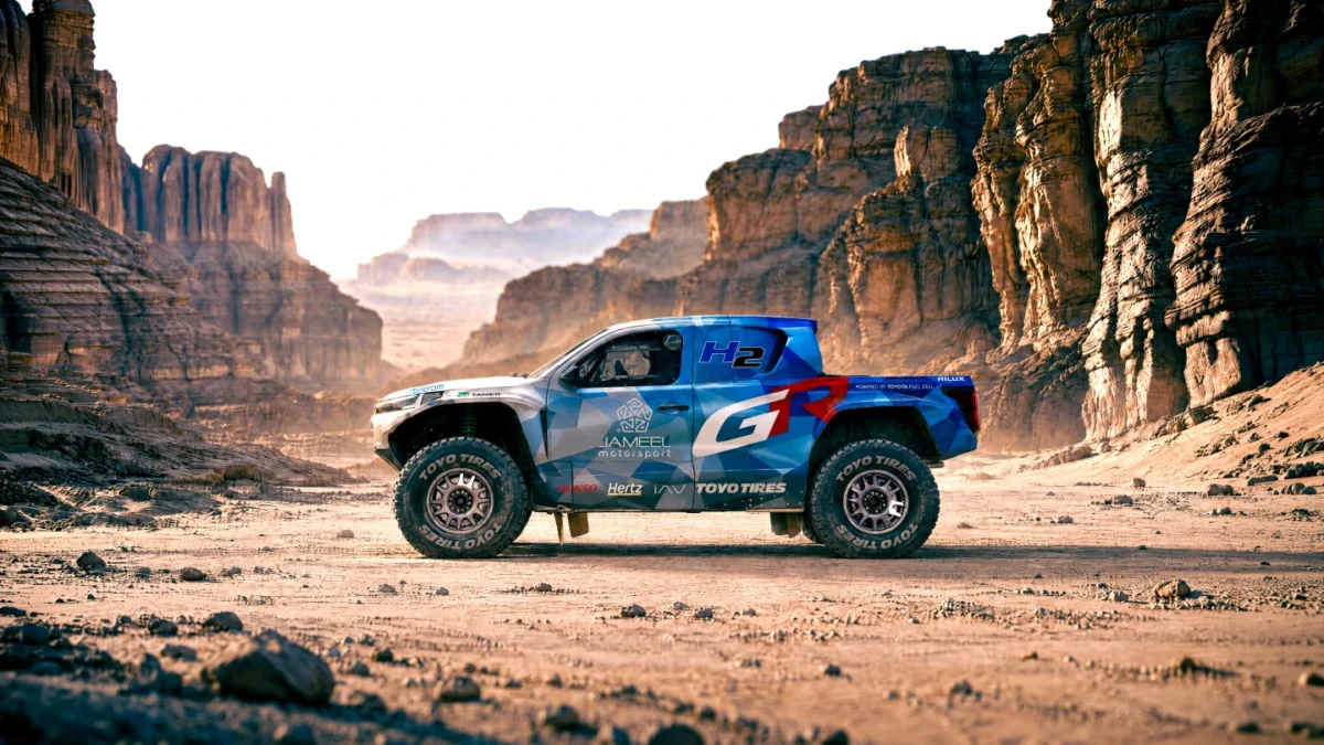 نمای جانبی Toyota DKR GR FC Hilux هیدروژنی در میان صخرهها و مسیر بیابانی