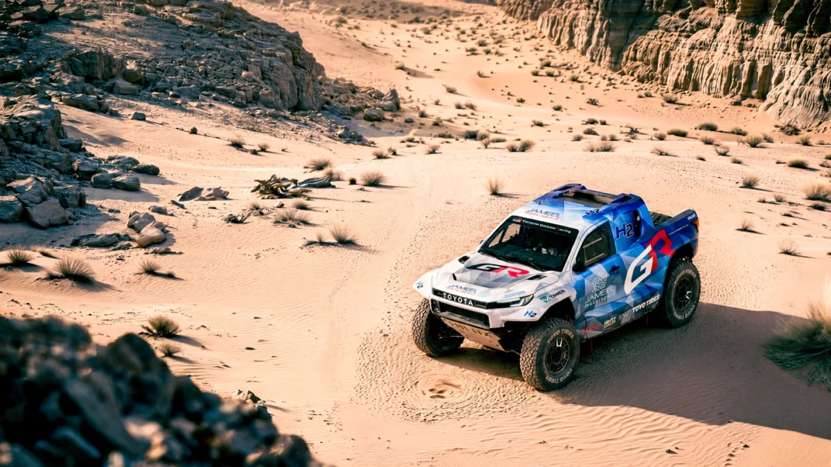 نمای بالاتر از وانت پیکاپ هیدروژنی Toyota DKR GR FC Hilux در مسیر شنی و صخرهای بیابان