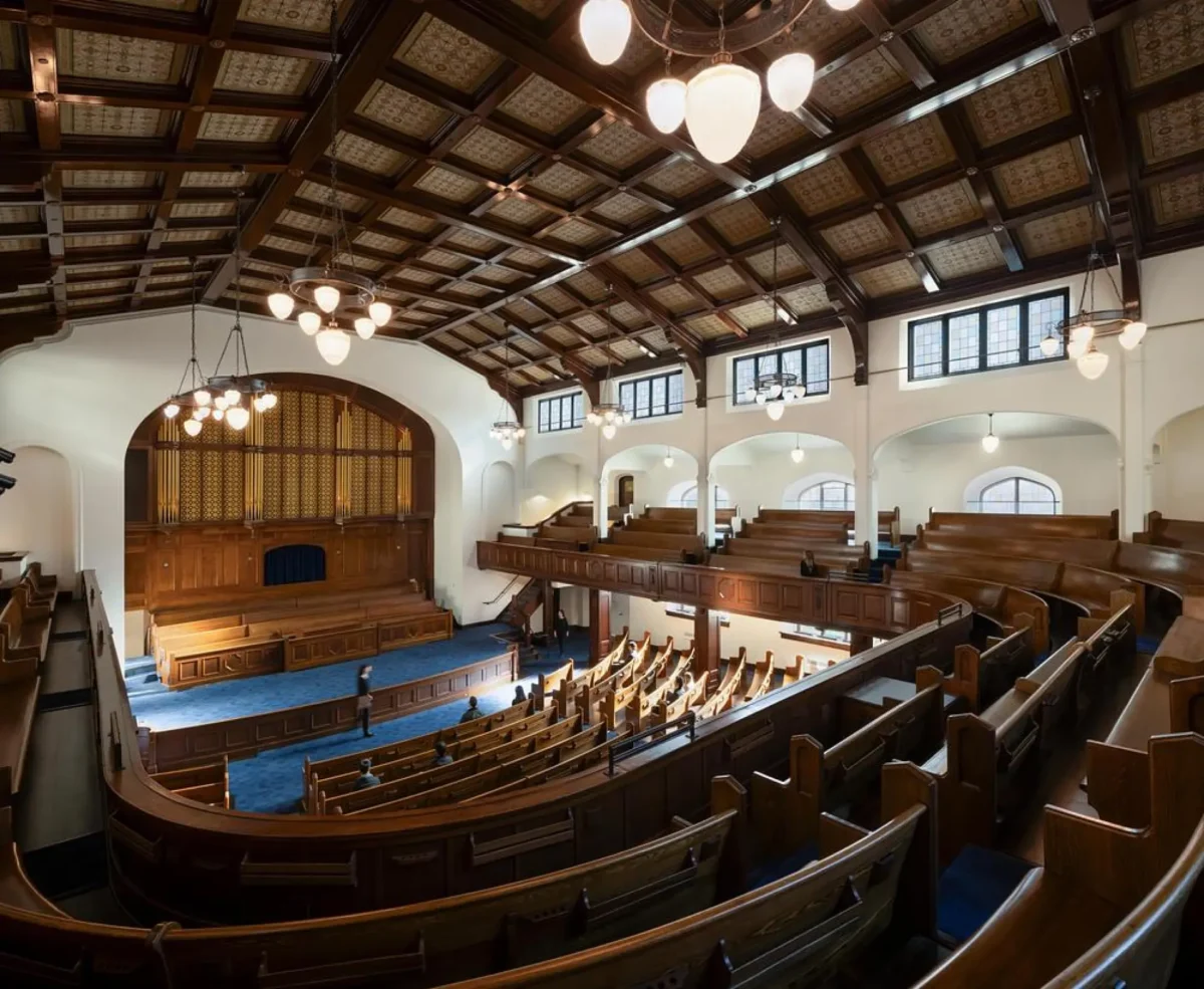 فضای داخلی مرمتشده کلیسای First Baptist Church با نیمکتها و سقف چوبی