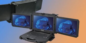 نمای سه‌بعدی باز و زاویه‌دار لپ‌تاپ صنعتی مقاوم Durabook با سه صفحه‌نمایش هم‌زمان که محیط دسکتاپ ویندوز ۱۱ را اجرا می‌کنند، در کنار نمای پشتی پنل‌های بسته تاشو روی پس‌زمینه گرادیان آبی و نارنجی.