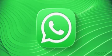 لوگوی واتساپ در مرکز تصویر؛ آیکون سبز گرد روی پس‌زمینه سبز موج‌دار با خطوط منحنی و واترمارک 9to5Mac در گوشه پایین راست.