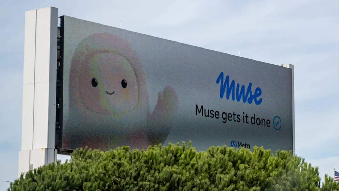 بیلبورد تبلیغاتی بزرگ دستیار هوش مصنوعی Muse شرکت متا با تصویر شخصیت کارتونی پشمالوی کرمرنگ و شعار Muse gets it done بالای درختان.